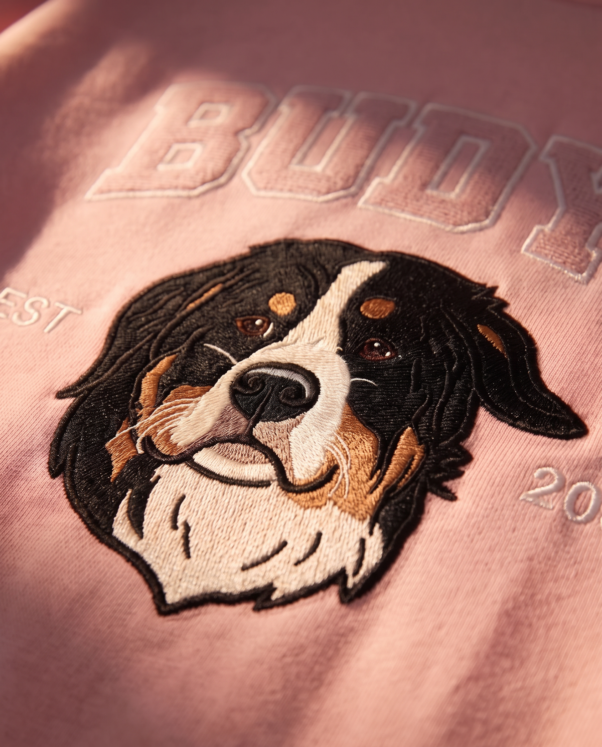 Close-up of the embroidered dog portrait and tone-on-tone collegiate lettering